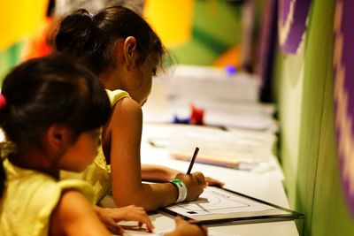 Girls writing in book at classroom