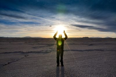 Man standing on landscape against blue sky during sunset