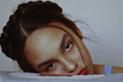 Close-up portrait of young woman relaxing on bed at home