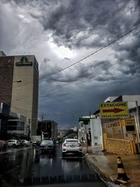 Vehicles on road against sky in city