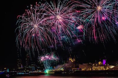 Low angle view of firework display at night