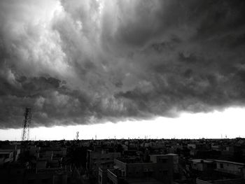 Panoramic view of houses against storm clouds