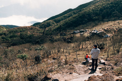 Rear view of man on landscape against mountains