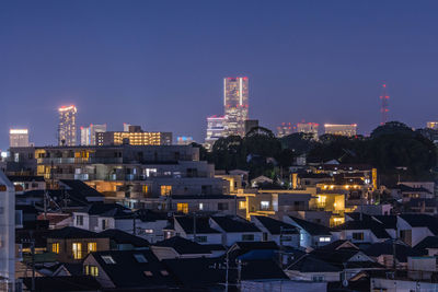Illuminated cityscape against sky at night