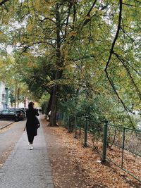 Rear view of woman walking on footpath