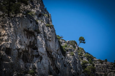 Low angle view of rock formation against clear blue sky