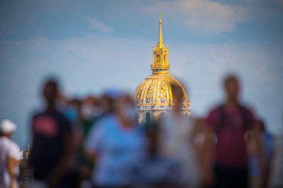 People in front of historical building against sky