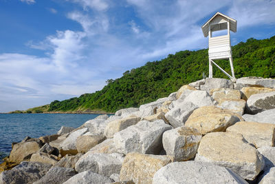 Scenic view of rocks by sea against sky