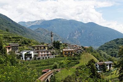 Houses by mountains against sky