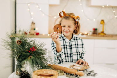 Portrait of a joyful girl holding a christmas decorative cookie in her hand. 