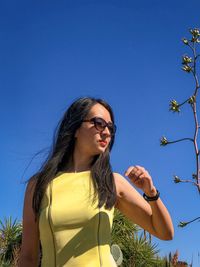 Low angle view of woman against blue sky