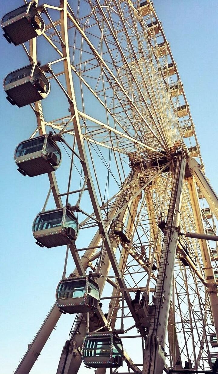 low angle view, ferris wheel, day, clear sky, outdoors, sky, no people, built structure, blue, amusement park ride