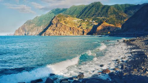 Scenic view of sea and mountains against sky