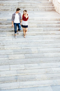 Full length of couple walking on staircase