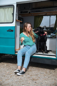 Woman sitting with dog in camper van