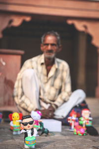 Portrait of man with toy sitting on table