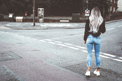 Rear view of a girl standing on the road 