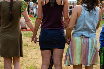 Rear view of people standing against blurred background