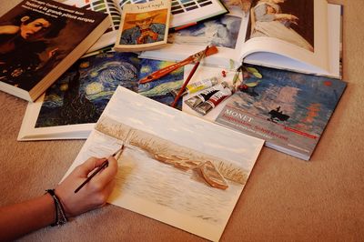 High angle view of person reading book on table