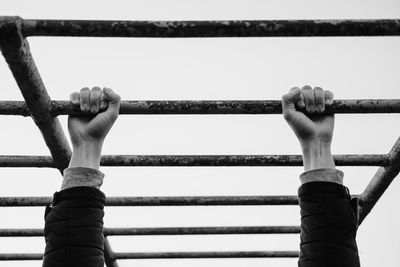 Low angle view of person holding rope against sky