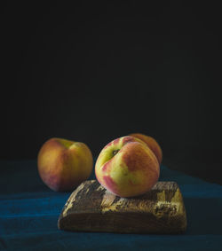 Close-up of apple on table against black background