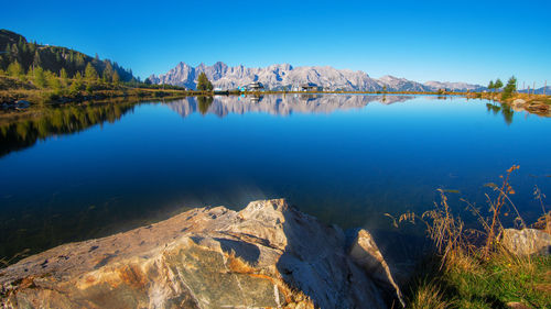 Scenic view of lake and mountains against blue sky