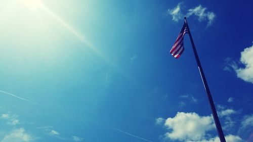 Low angle view of flag against blue sky