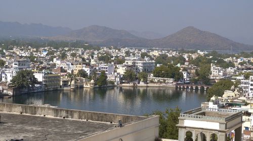 Aerial view of townscape by mountain against sky