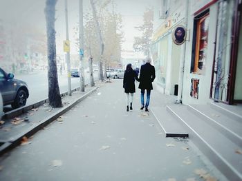 Rear view of men on wet road