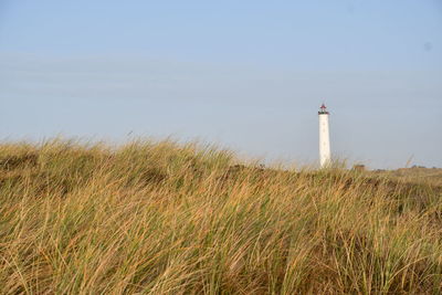 Lighthouse by sea against sky