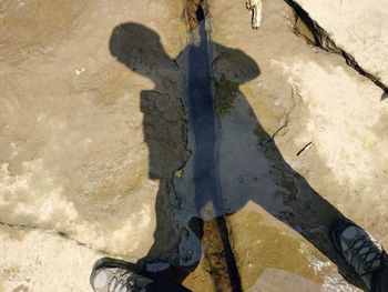 Low section of person with shadow on puddle