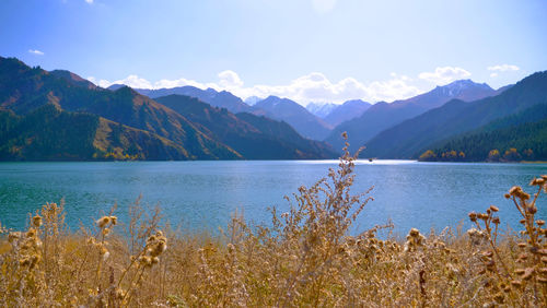 Scenic view of lake by mountains against sky