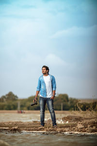 Full length portrait of young man standing on land
