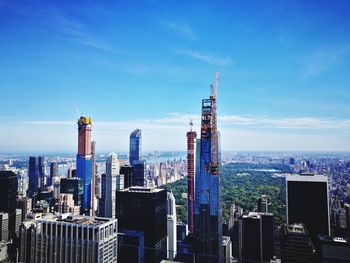 Modern buildings in city against blue sky