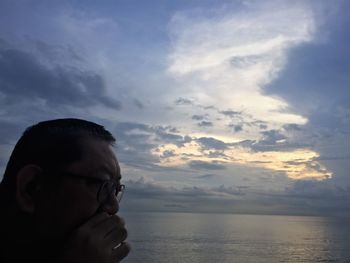 Boy looking at sea against sky