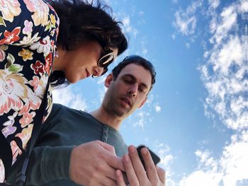 Young couple kissing against sky