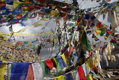 Low angle view of prayer flags against cloudy sky