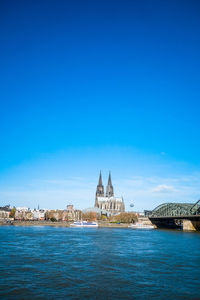 River with buildings against blue sky