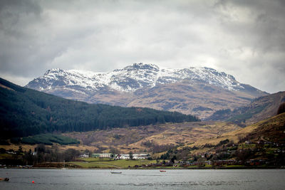 Scenic view of snowcapped mountains against cloudy sky