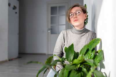 Portrait of young woman wearing eyeglasses at home