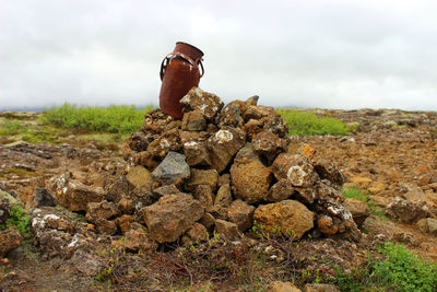 Stack of rocks on field against sky