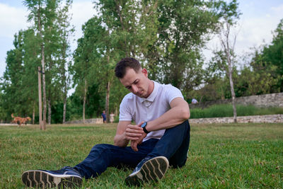 Portrait of young man sitting on field