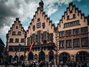 People on street against buildings in city