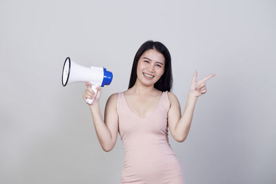 Portrait of a smiling young woman against white background