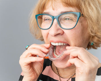 Portrait of woman holding dental braces