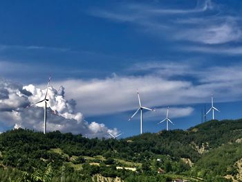 Wind turbines on land against sky