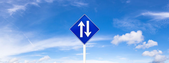 Low angle view of road sign against sky