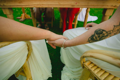 Midsection of couple holding hands