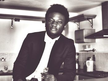 Portrait of businessman in suit in kitchen