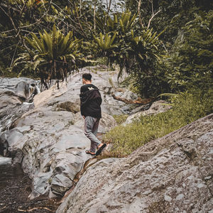 Rear view of man walking on rock